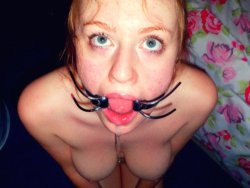 Redhead MILF with a mouth gag gives a deepthroat